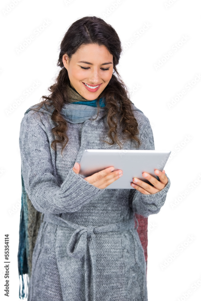 Smiling pretty brunette wearing winter clothes holding her table Smiling pretty brunette wearing winter clothes holding her table