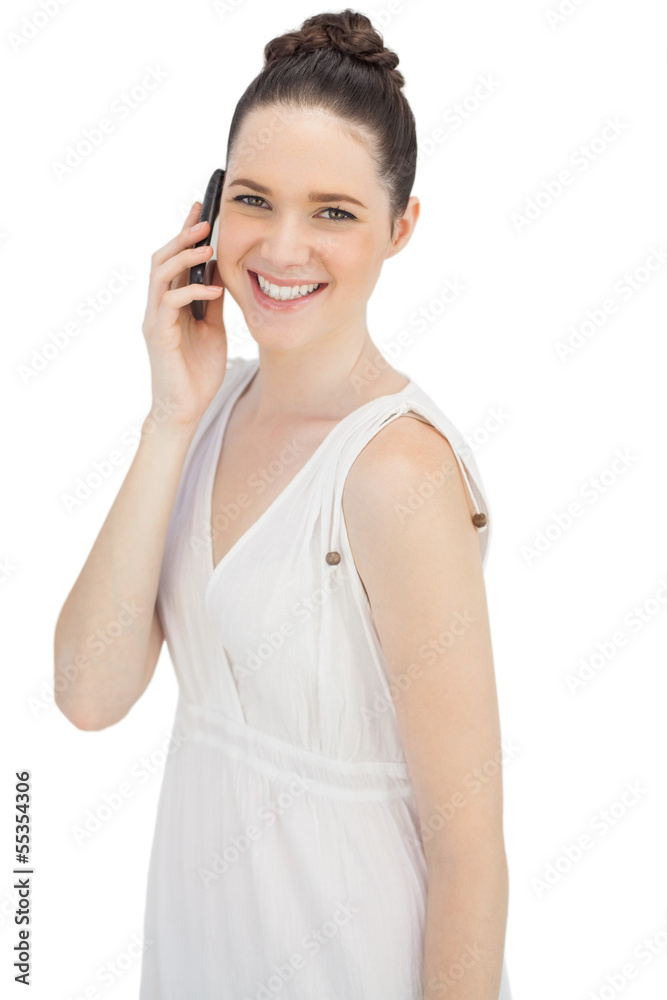 Smiling young model in white dress having phone call Smiling young model in white dress having phone call