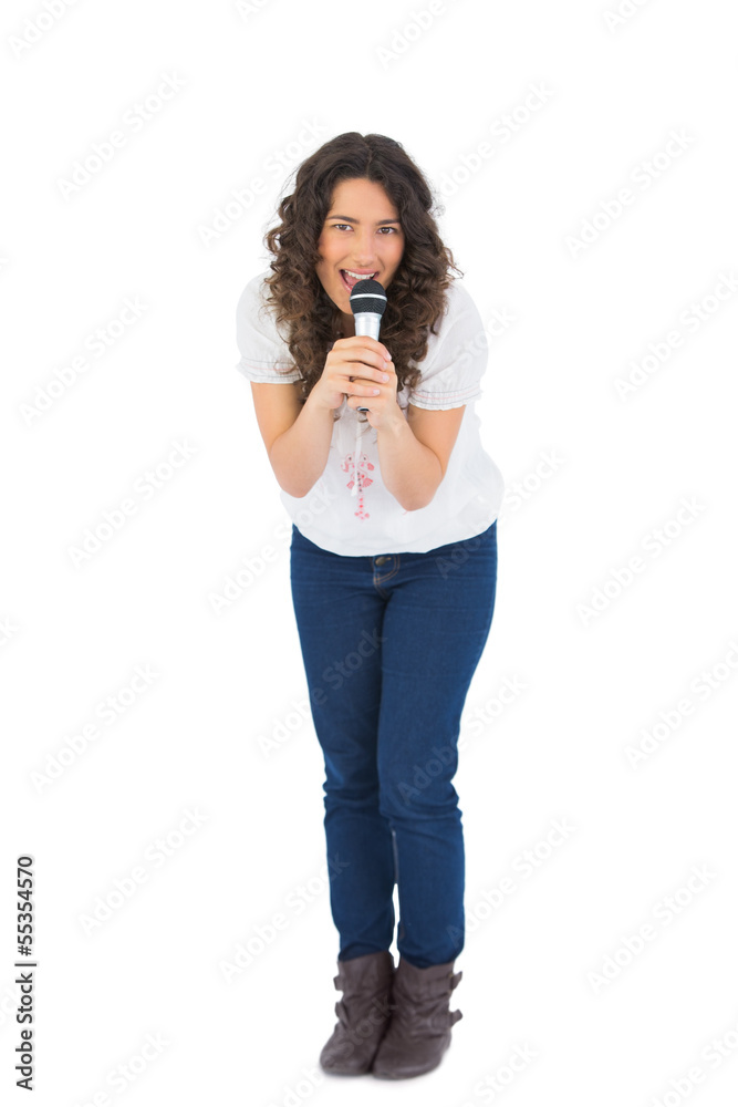 Happy pretty brunette singing with her microphone Happy pretty brunette singing with her microphone