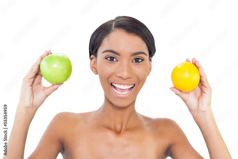 Smiling attractive model holding fruits in both hands