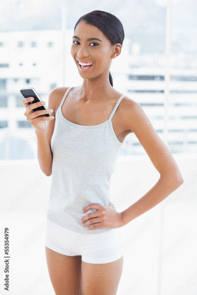 Happy sporty model using her smartphone