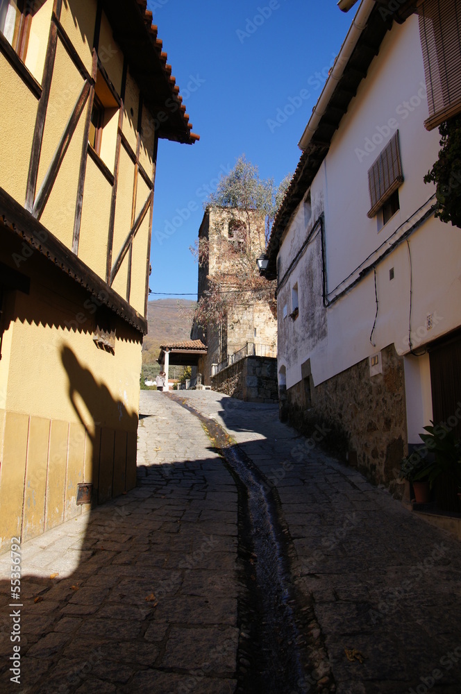 Typical street,steep slope, waterway in the street, church tower