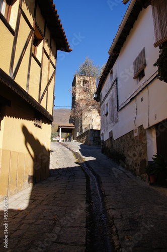 Typical street,steep slope, waterway in the street, church tower © laagudo