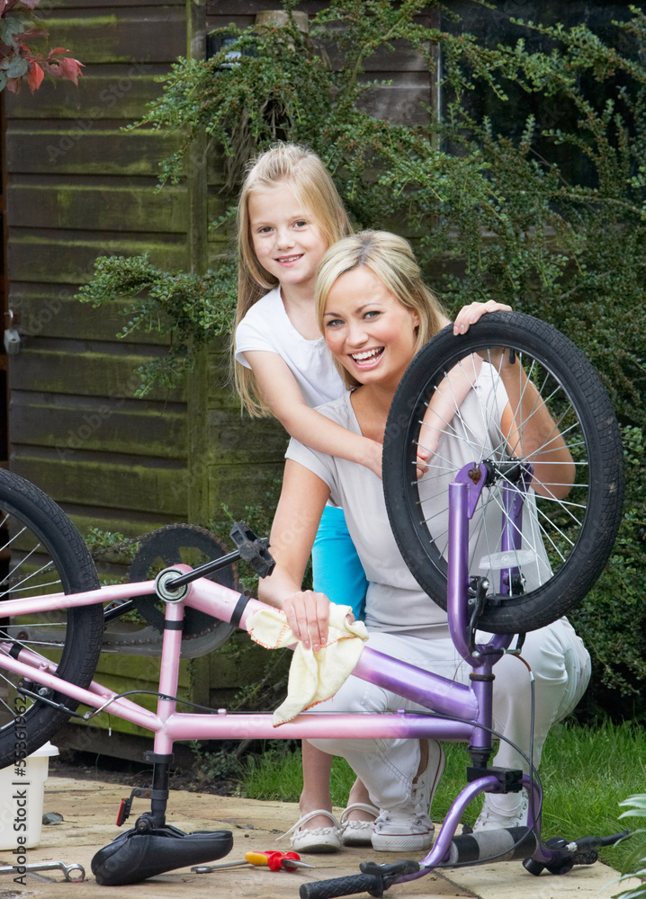 Obraz premium Mother And Daughter Cleaning Bike Together