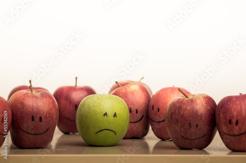 Obraz na płótnie Green and sad apple among red and happy apples w salonie