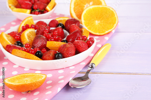 Useful fruit salad in plates on wooden table close-up