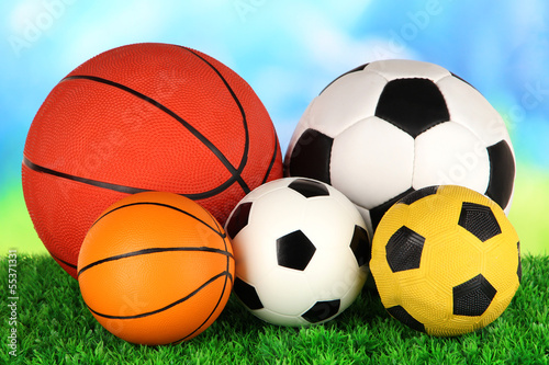 Sport balls, on green grass, on bright background © Africa Studio