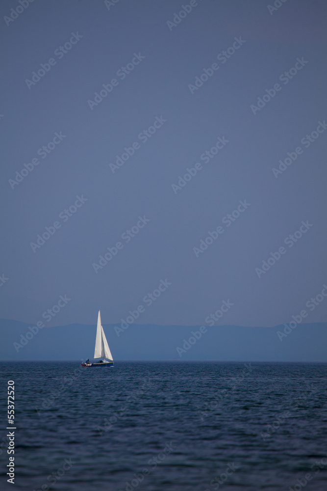 a small sailboat on the lake horizon