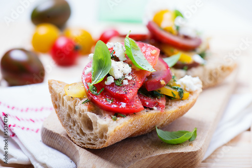 sandwich with red, yellow and black tomatoes and feta cheese