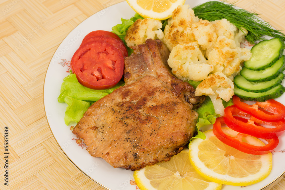 Grilled pork chop with a side dish of cauliflower and vegetables Grilled pork chop with a side dish of cauliflower and vegetables
