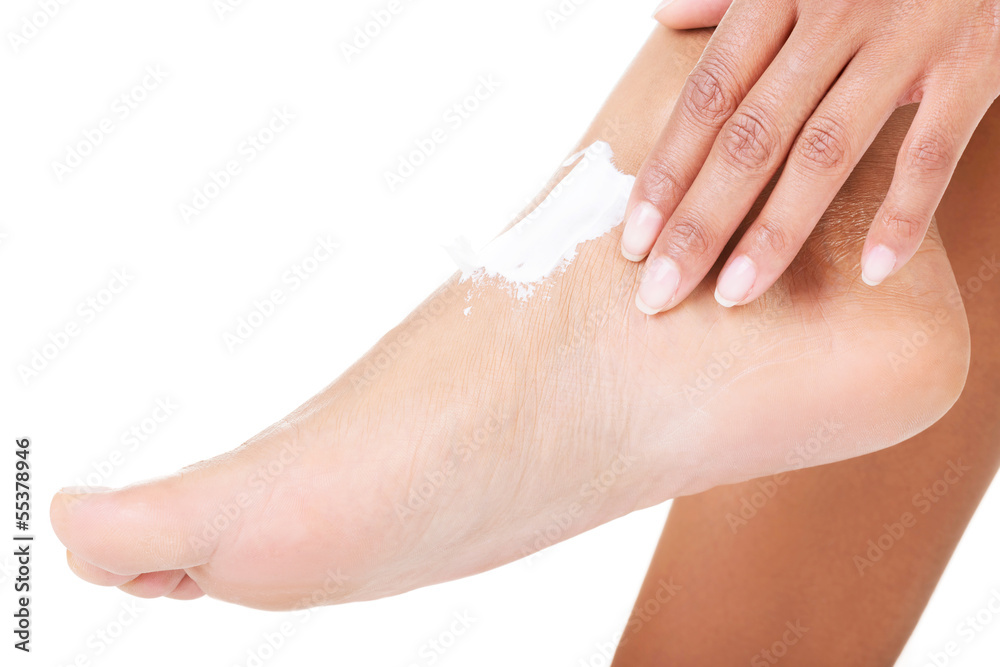 Female hands treating feet with moisturizing cream Female hands treating feet with moisturizing cream