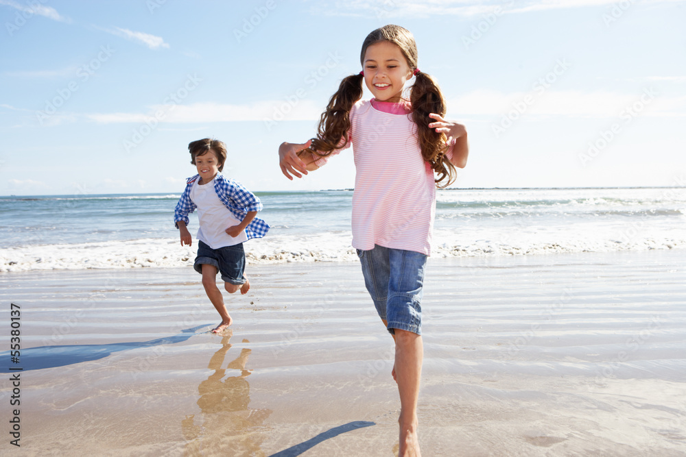Children Running Away From Breaking Waves On Beach Children Running Away From Breaking Waves On Beach