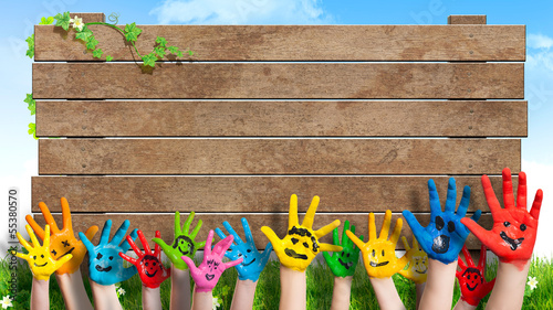 lanchende Kinderhände vor Holzschild photo