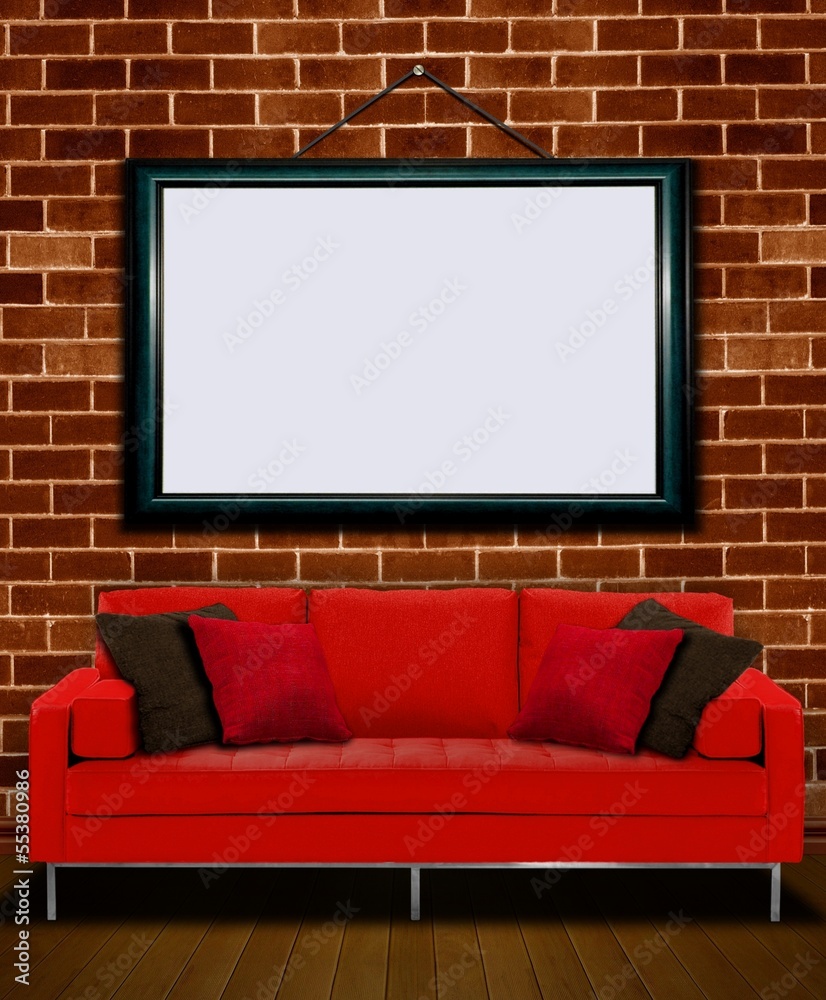 Red sofa with picture frame over brick wall Red sofa with picture frame over brick wall