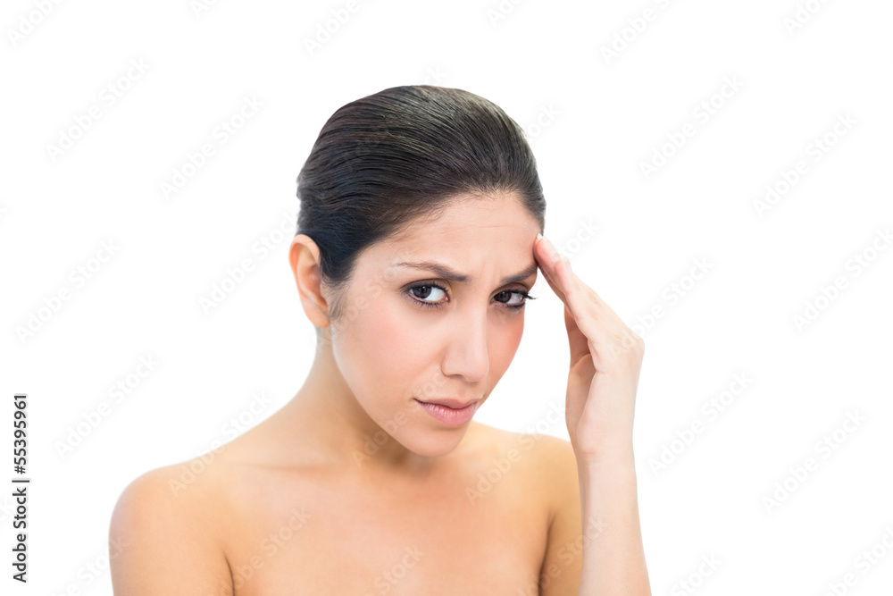 Frowning brunette with a headache looking at camera Frowning brunette with a headache looking at camera
