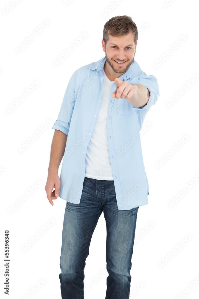 Smiling young model pointing at camera Smiling young model pointing at camera