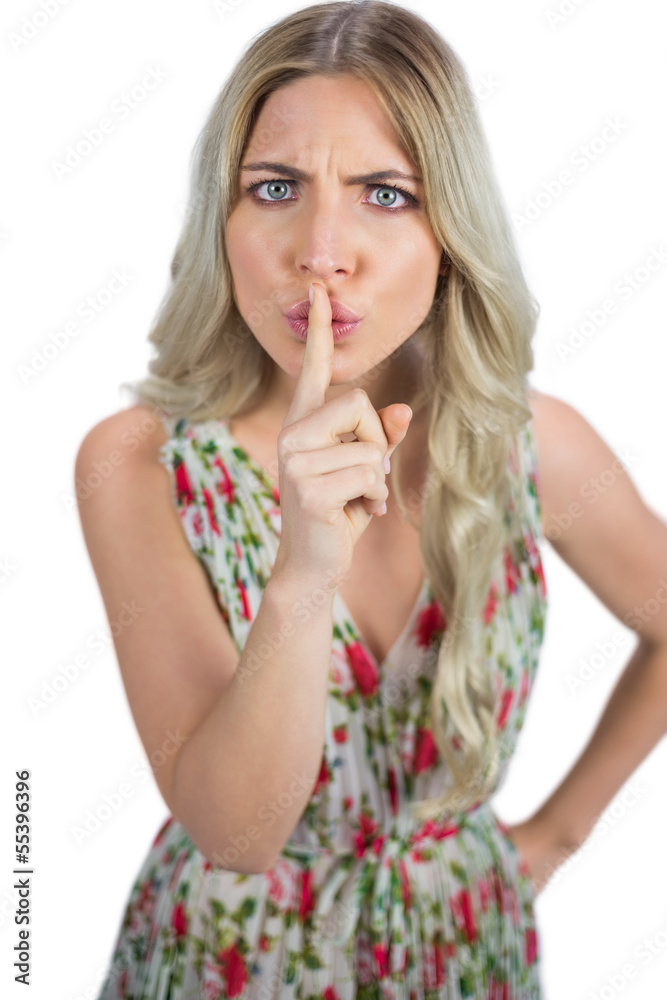 Frowning blond model wearing flowered dress hiding secret Frowning blond model wearing flowered dress hiding secret