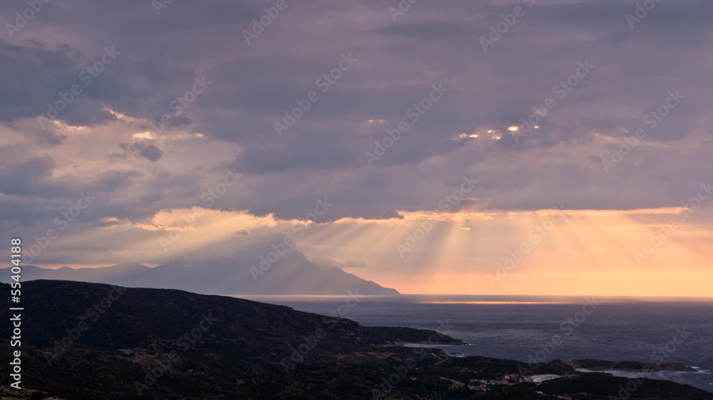 Divine light, stormy sky and sunrise around holy mountain Athos