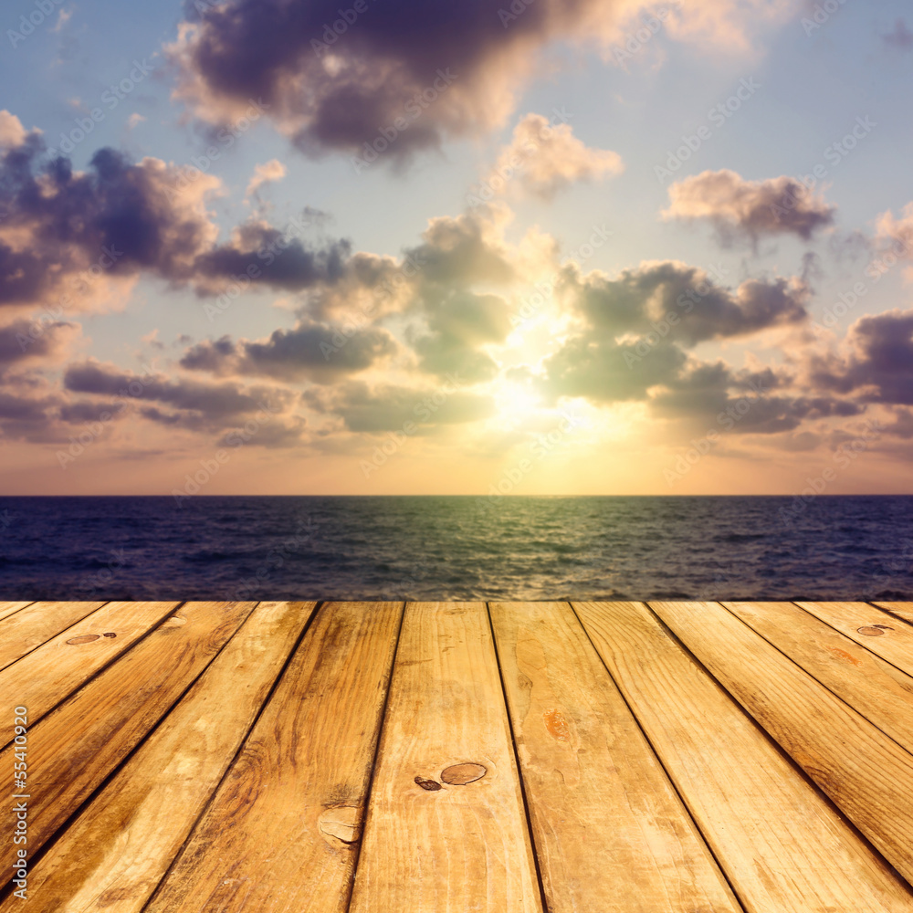 Empty wooden deck floor over sea and sunset background