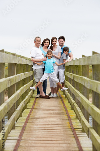 Multi Generation Family Walking Along Wooden Bridge © micromonkey
