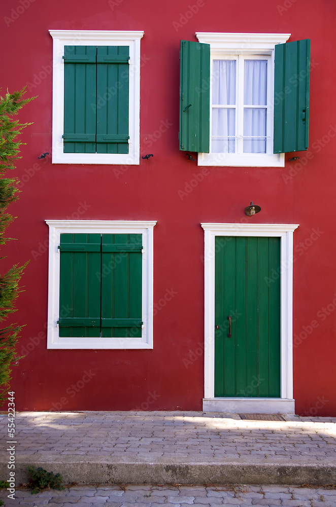 Green shutters on a red wall, in Nafplio, Greece