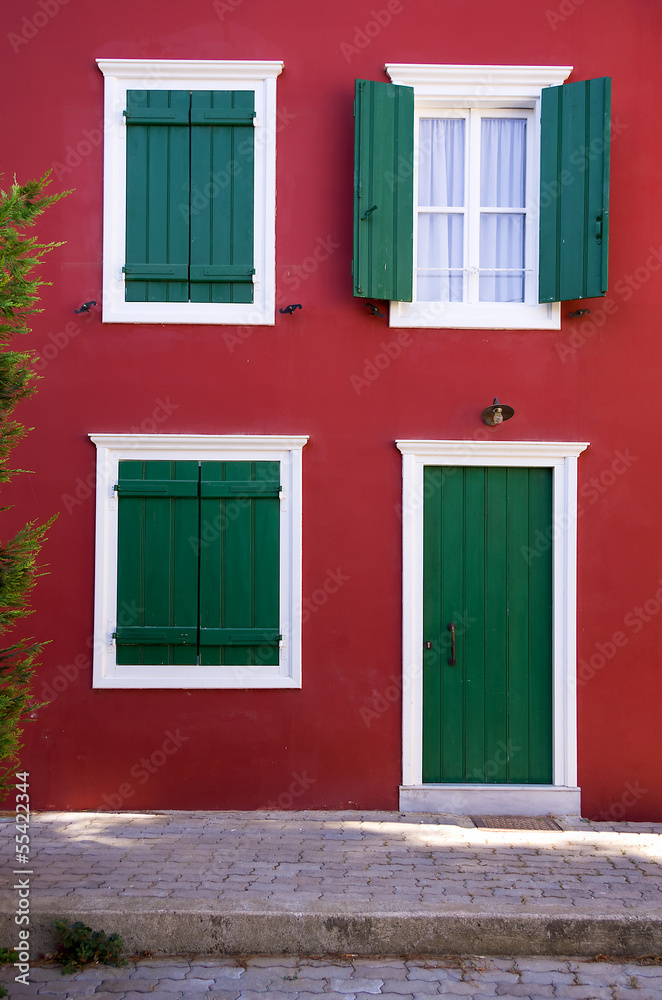 Green shutters on a red wall, in Nafplio, Greece Green shutters on a red wall, in Nafplio, Greece