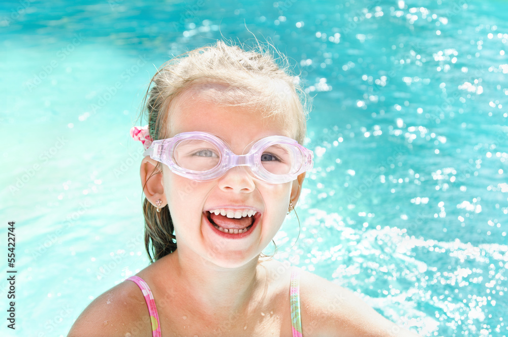 Naklejka premium Pretty smiling little girl in swimming pool