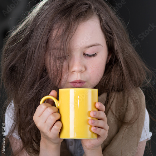 Girl blowing on hot beverage