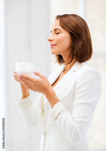 businesswoman with cup of coffee in office
