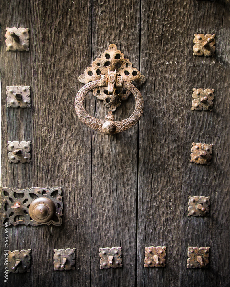 Closeup of old ornate wood door with brass knocker