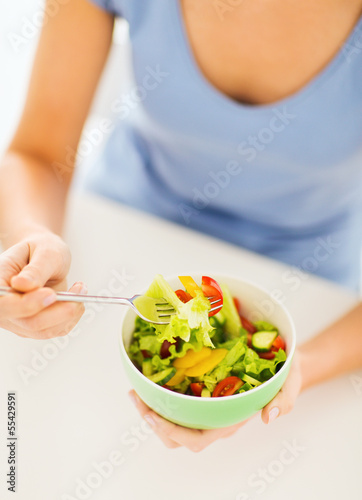 woman eating salad with vegetables