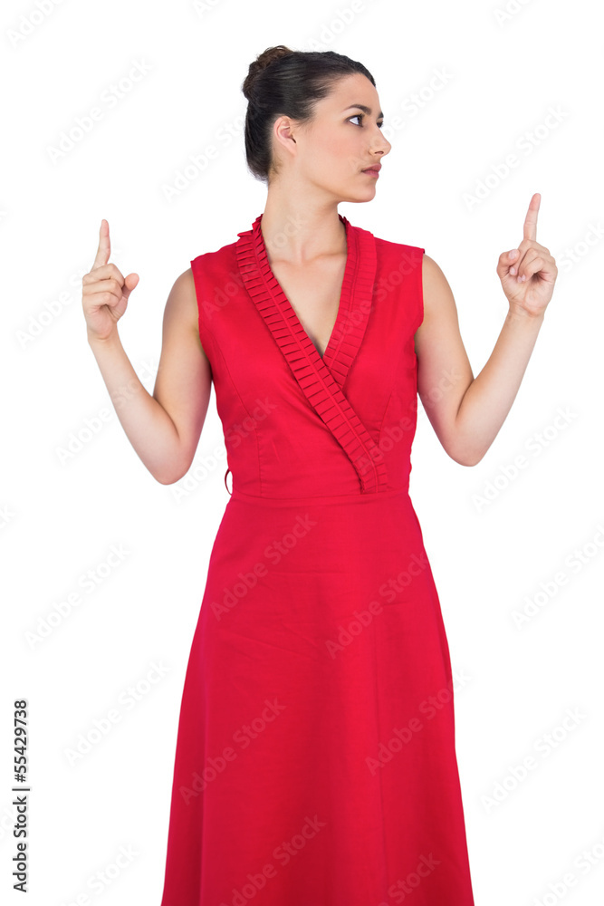 Glamorous model in red dress pointing up Glamorous model in red dress pointing up
