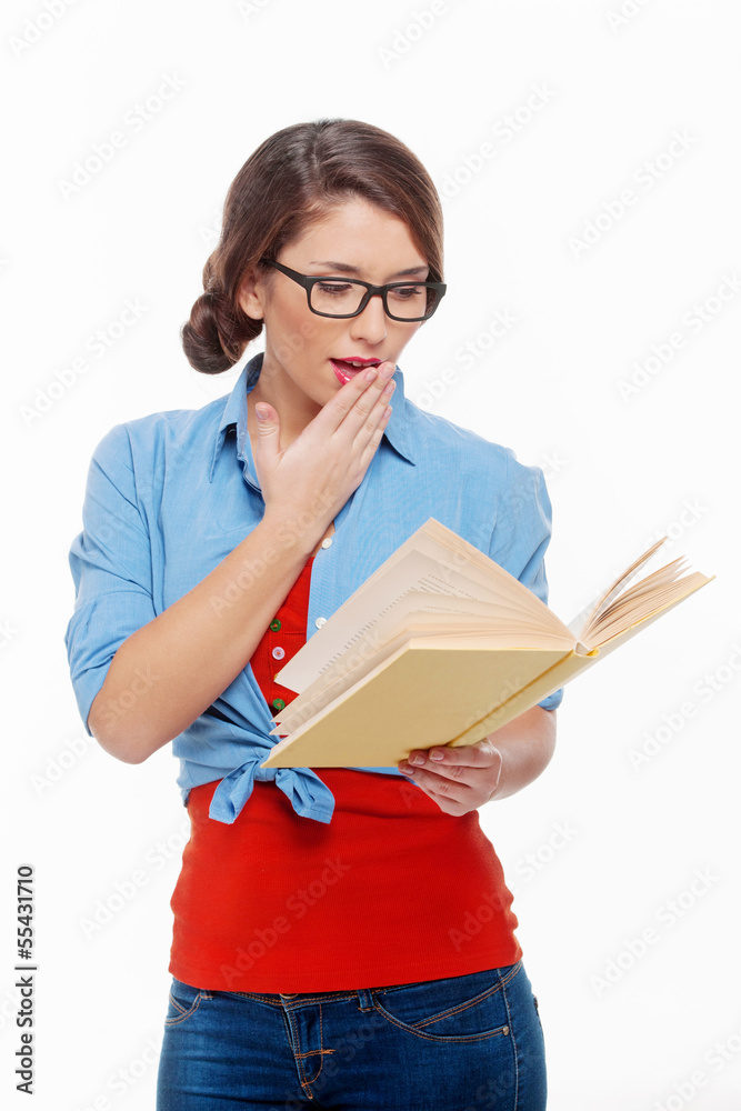 Reading an exciting book. Surprised young woman in glasses readi Reading an exciting book. Surprised young woman in glasses readi