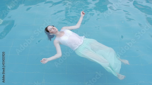 drowned woman body floating in a swimming pool facing up