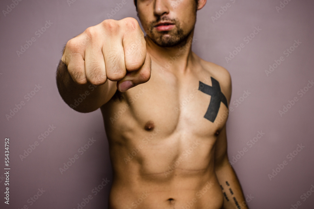 Fototapeta premium Young man with muscular physique punching