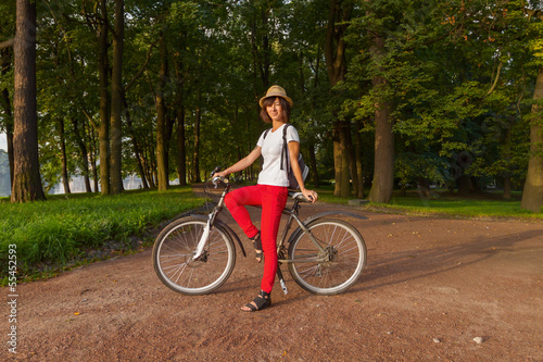 Hipster beautiful girl on a bicycle in the park