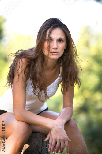 Portrait of young attractive brunette woman at park