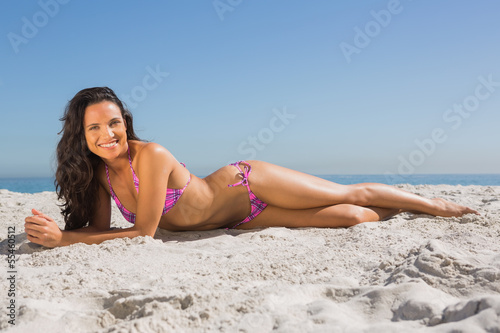 Smiling slim young woman posing while lying
