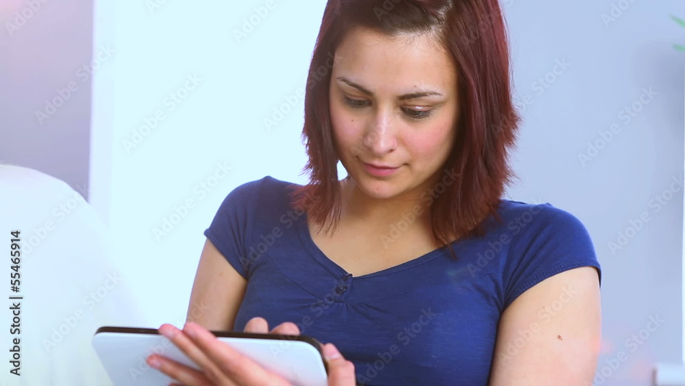 Smiling young woman using her digital tablet Smiling young woman using her digital tablet