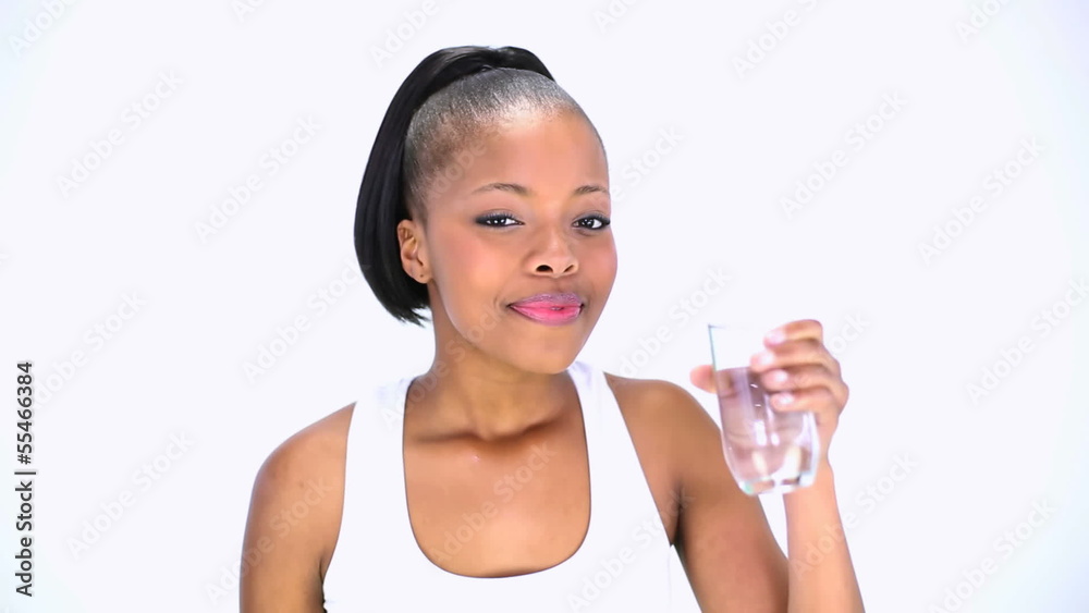 Cheerful model in sportswear drinking water