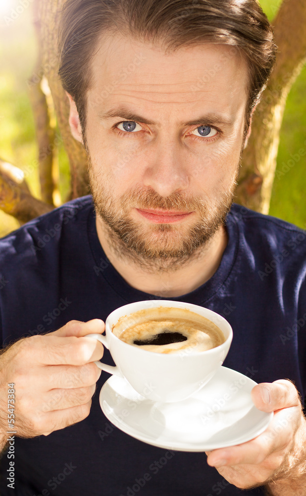 Serious man drinking morning coffee in the garden Serious man drinking morning coffee in the garden