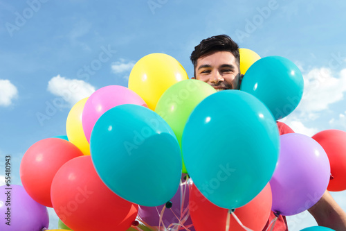 casual man surrounded by baloons
