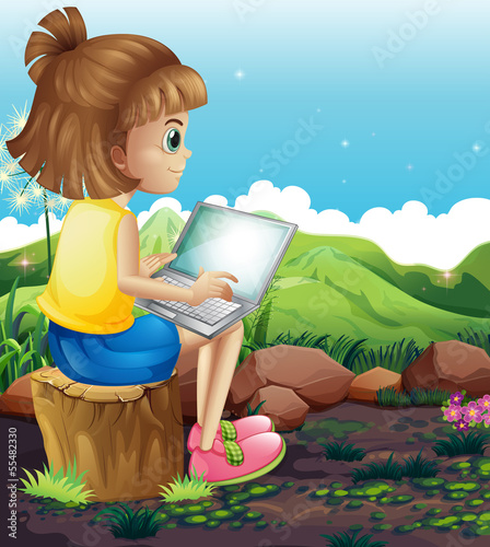 A young girl sitting above the stump while using the laptop