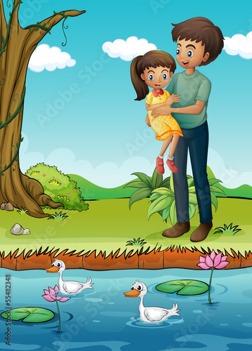 A young girl and her father at the riverbank