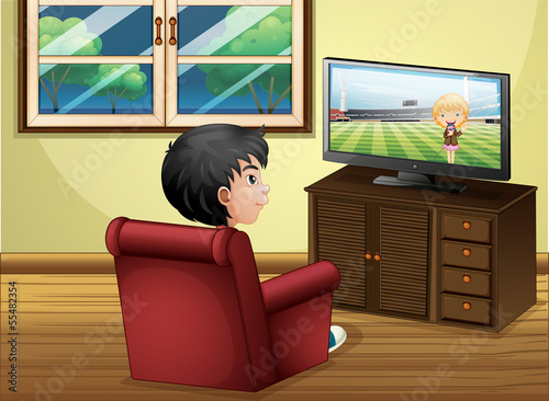 A young boy watching TV at the living room