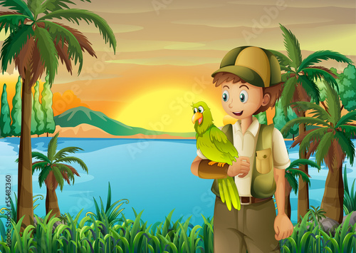 A boy with a parrot at the riverbank