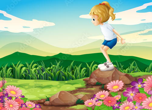 A young girl playing at the hilltop with rocks and a garden