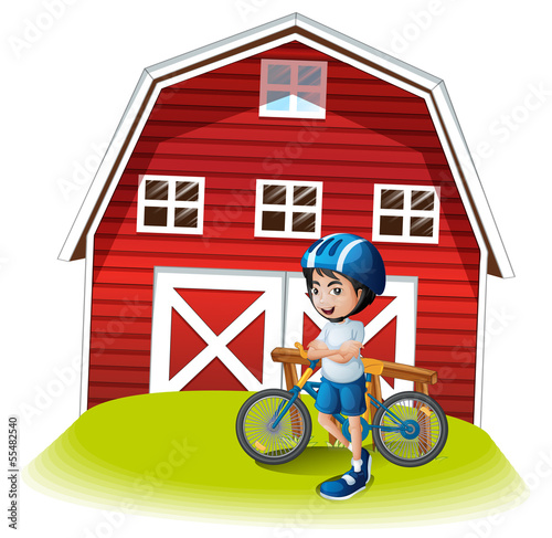 A boy with a bike standing in front of the farmhouse