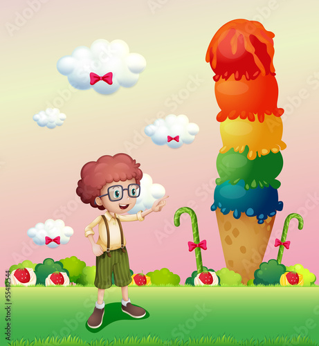 A young gentleman standing near the giant icecream