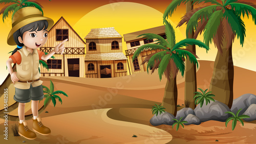 A young girl at the desert standing near the palm trees